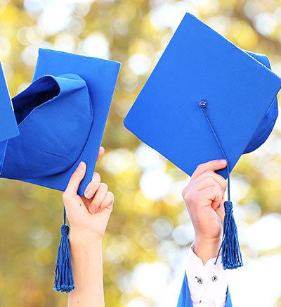 Students holding graduation caps